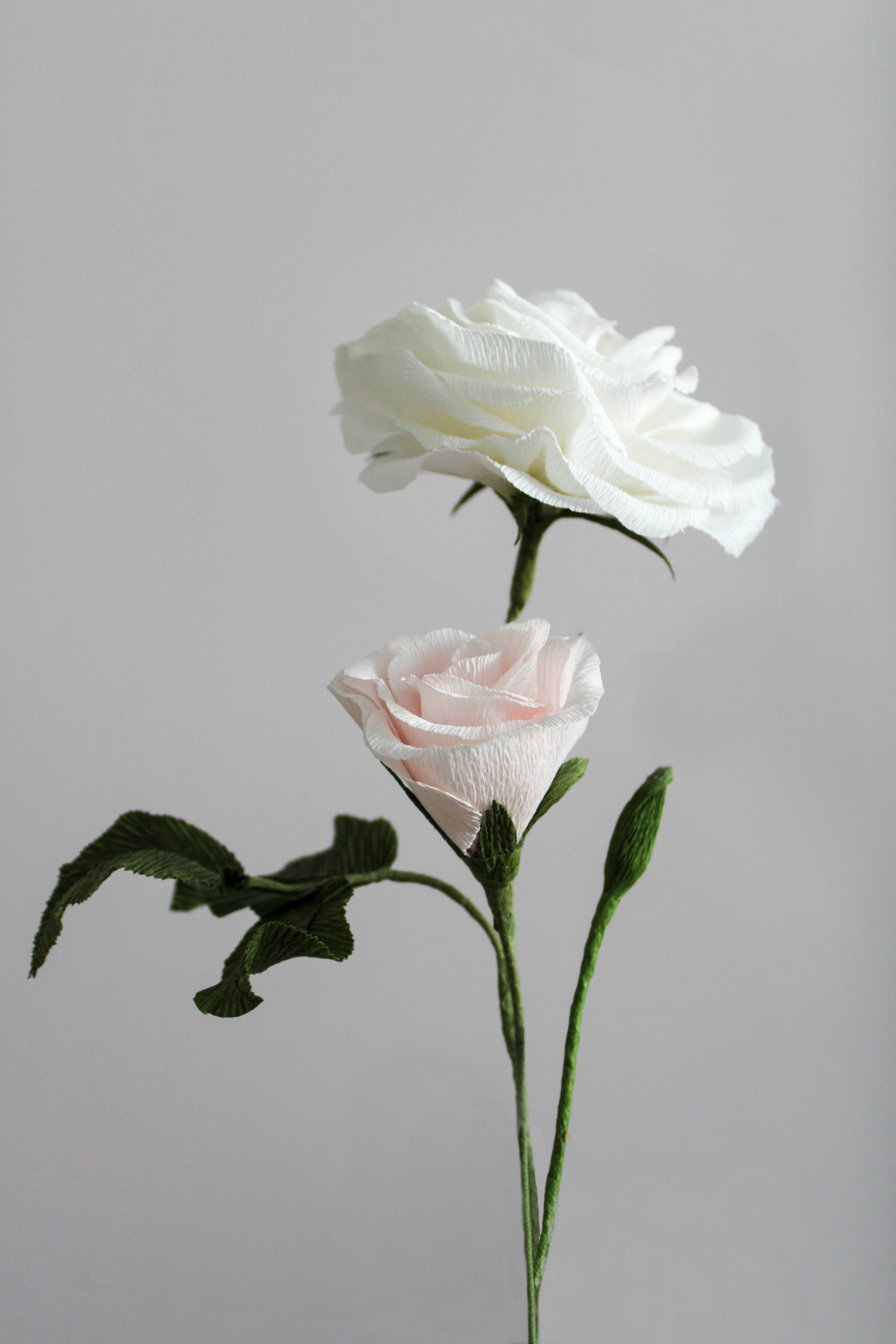 Composition de fleur en papier, comprenant une rose, un bouton de rose et un bourgeon.