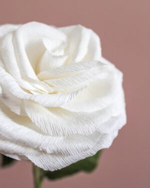 Zoom sur une rose en papier, sur un fond rose