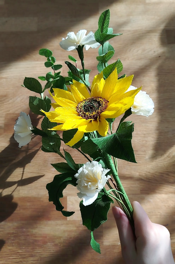 Bouquet de fleurs en papier composé d'un tournesol, de deux braches de d’œillets spray, de trois branches de ruscus et une branche d’eucalyptus.
